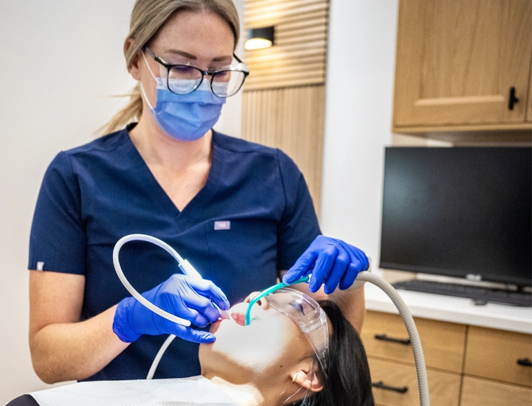 SMiiL Heights dental hygienist discussing treatment plan with patient at cozy Calgary clinic