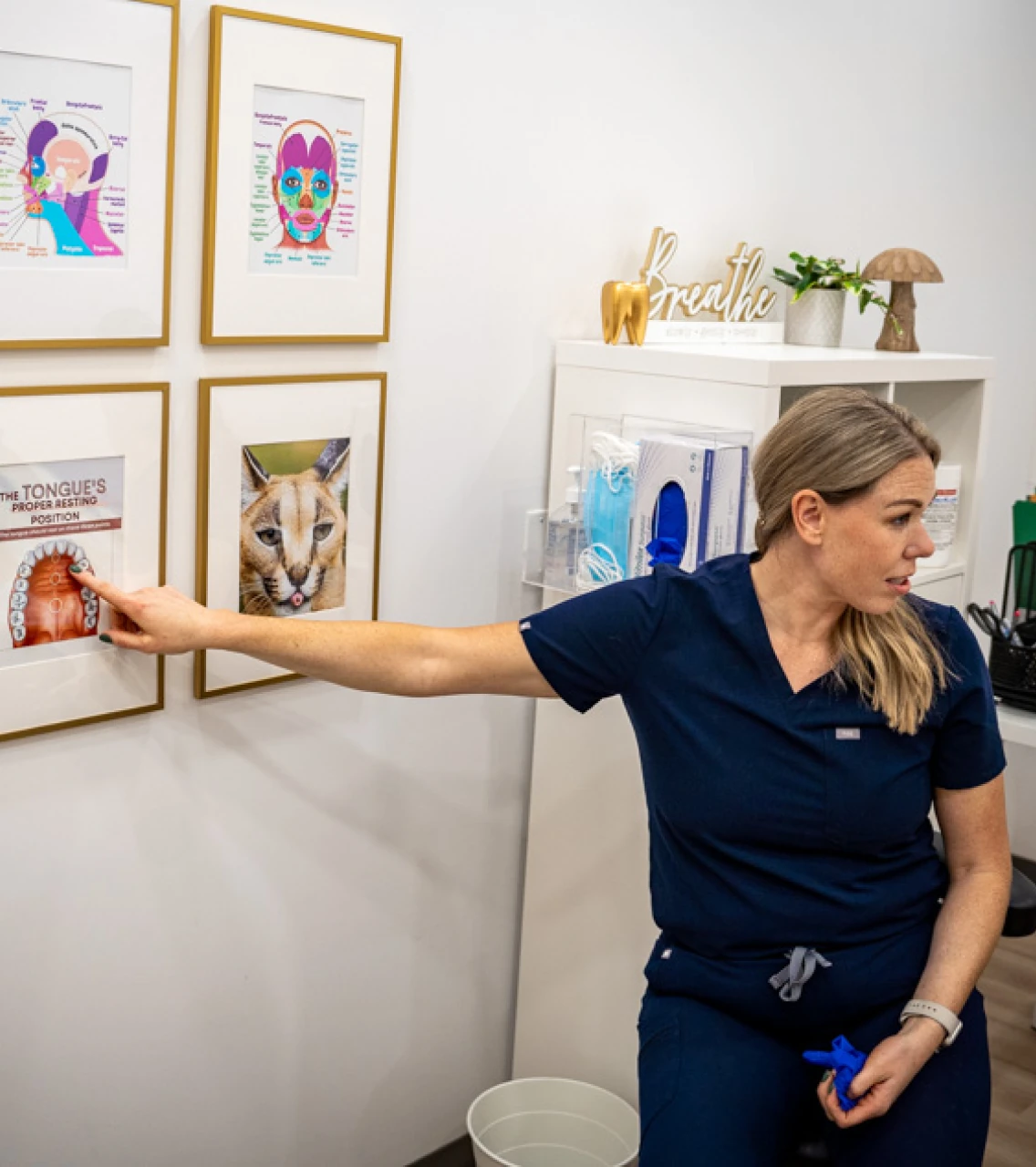 SMiiL Heights hygienist explaining dental illustrations on wall to patient during visit