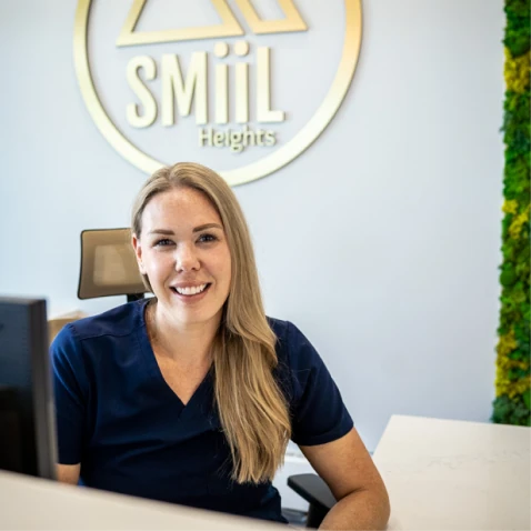 Friendly SMiiL Heights owner Elyse, welcoming patients at the front desk in Calgary dental hygiene clinic