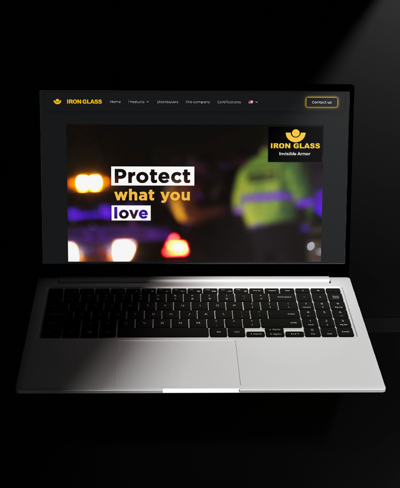 Laptop showing the Iron Glass website homepage with the tagline “Protect what you love”