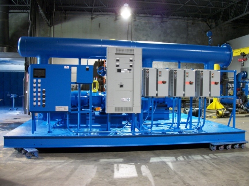 Large blue industrial machine with control panels and pipes mounted on a platform with wheels.