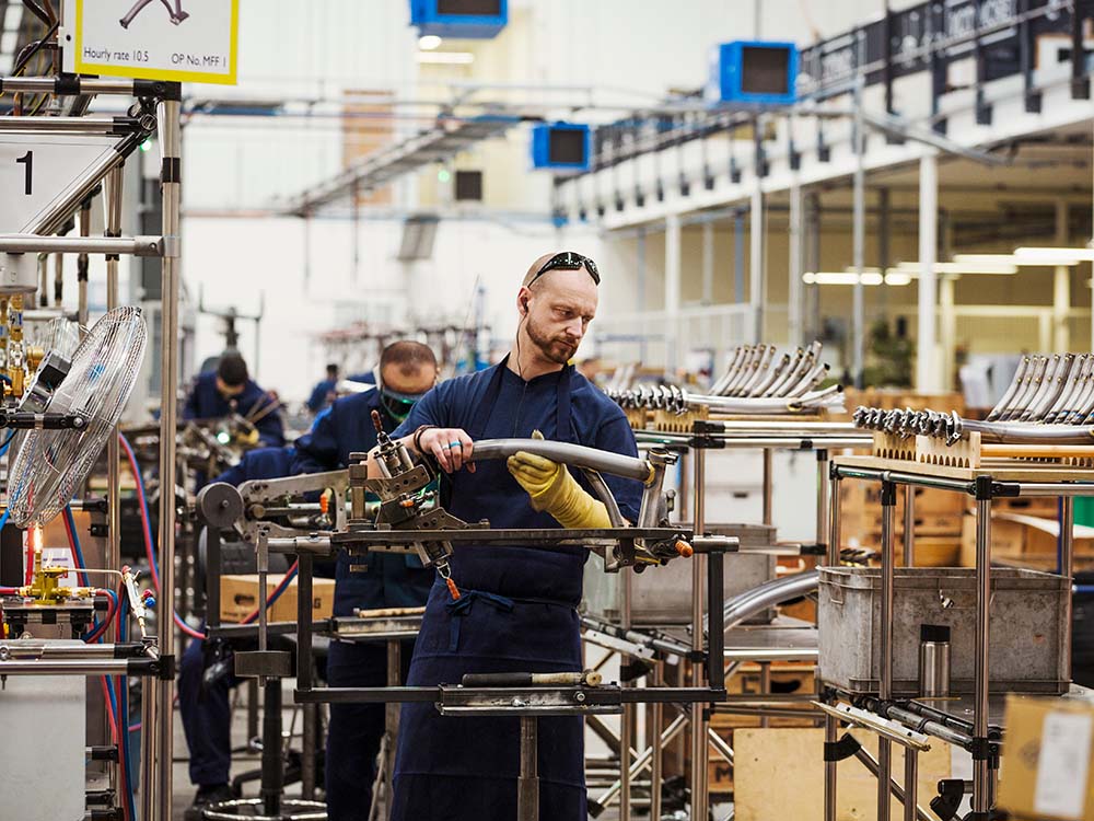 Factory team member assembling equipment, demonstrating standardized work in production