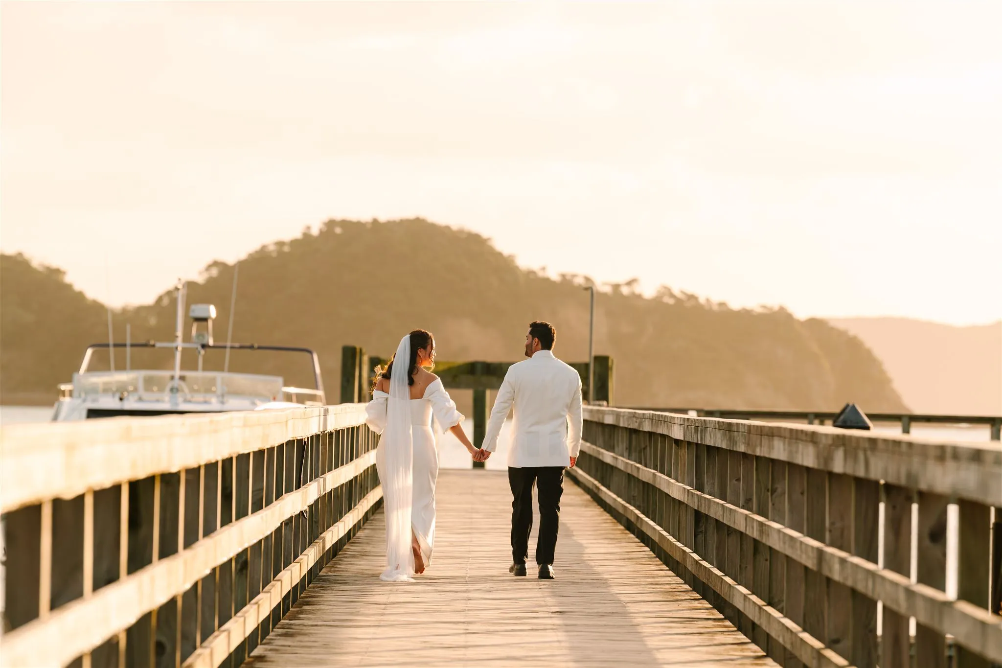 An engaged couple walking and laughing together in Northland, dressed like themselves