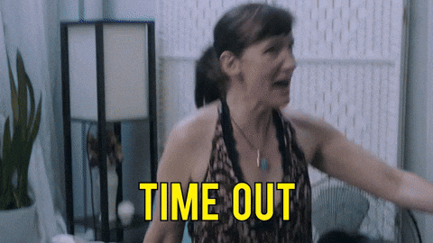 A woman gestures with her arm extended saying 'TIME OUT' in yellow text.
