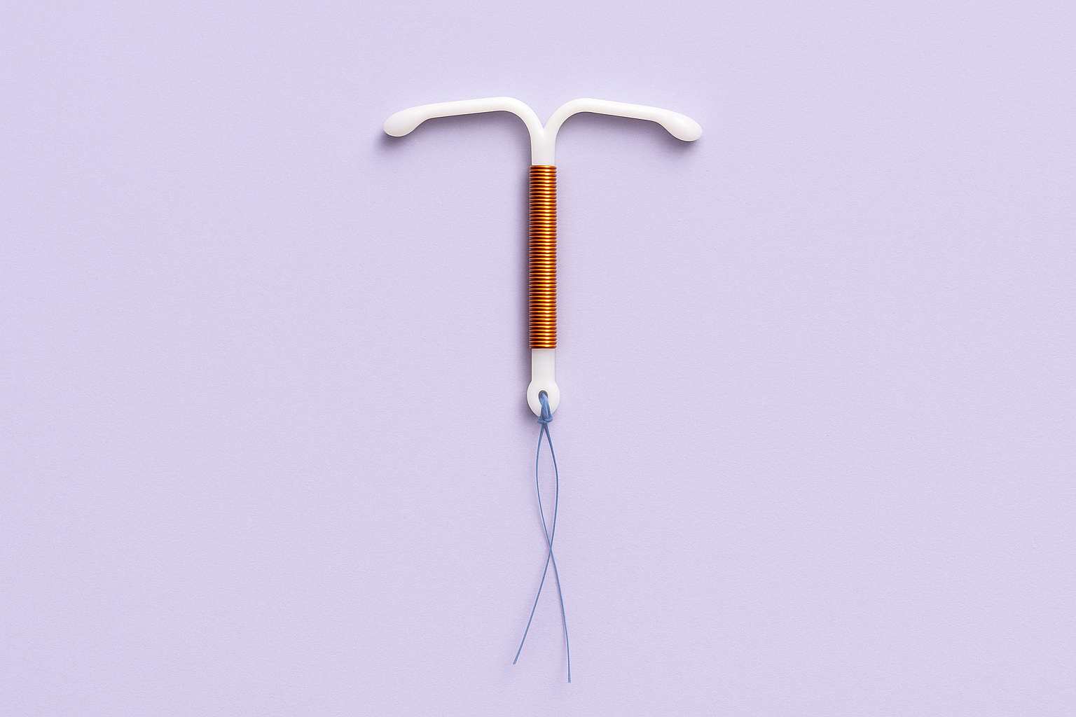 Copper intrauterine device (IUD) contraceptive with T-shaped white plastic frame and copper coil wrapped around the vertical stem.