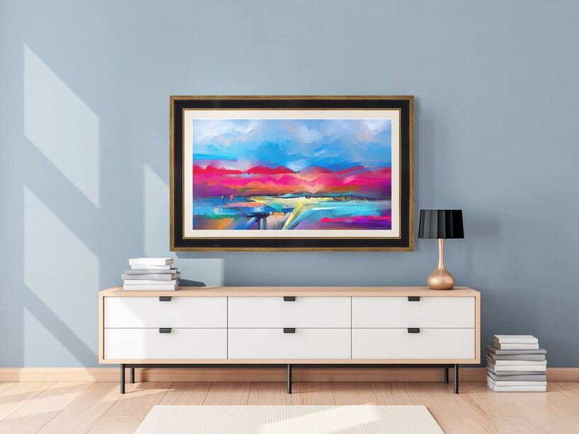 Modern living room interior with a white sideboard, black table lamp, and a colorful abstract landscape painting
