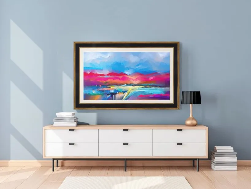 Modern living room interior with a white sideboard, black table lamp, and a colorful abstract landscape painting
