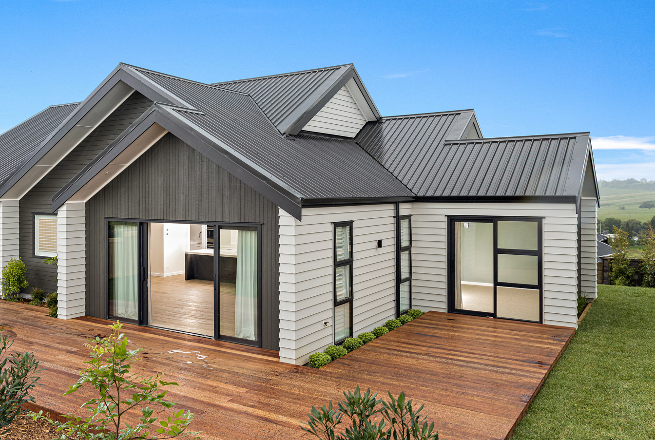 New build in Leigh featuring black aluminium sliding doors and windows, with a modern weatherboard exterior and timber decking