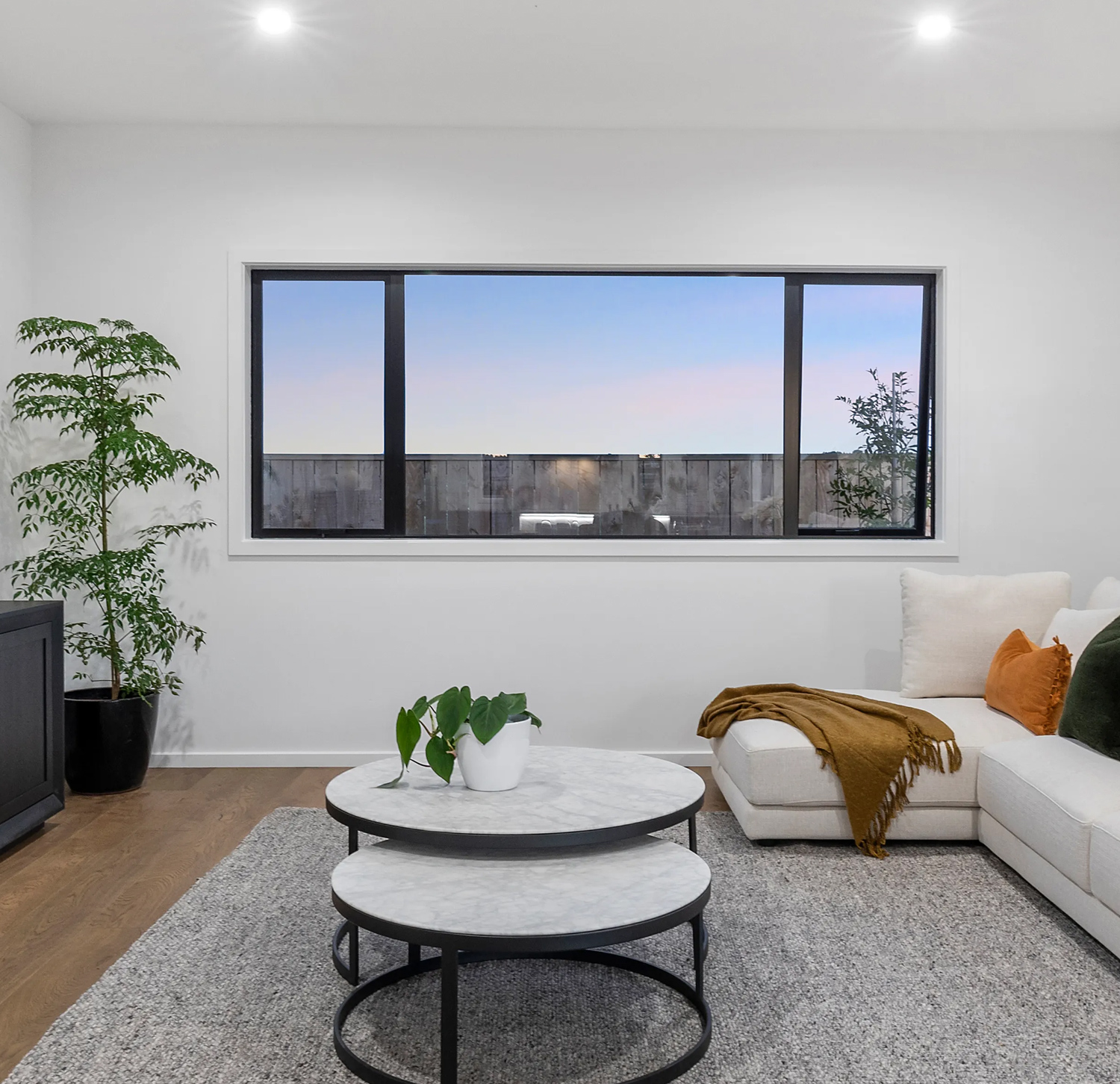 Modern living room with awning and casement aluminium windows in a new build home in Silverdale, featuring sleek black window frames and contemporary interior styling.