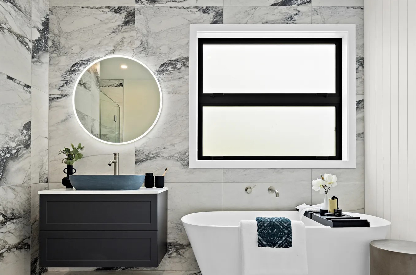Modern bathroom with freestanding bathtub and Etchlite obscured glass window, providing privacy and natural light – Rodney Aluminium NZ.