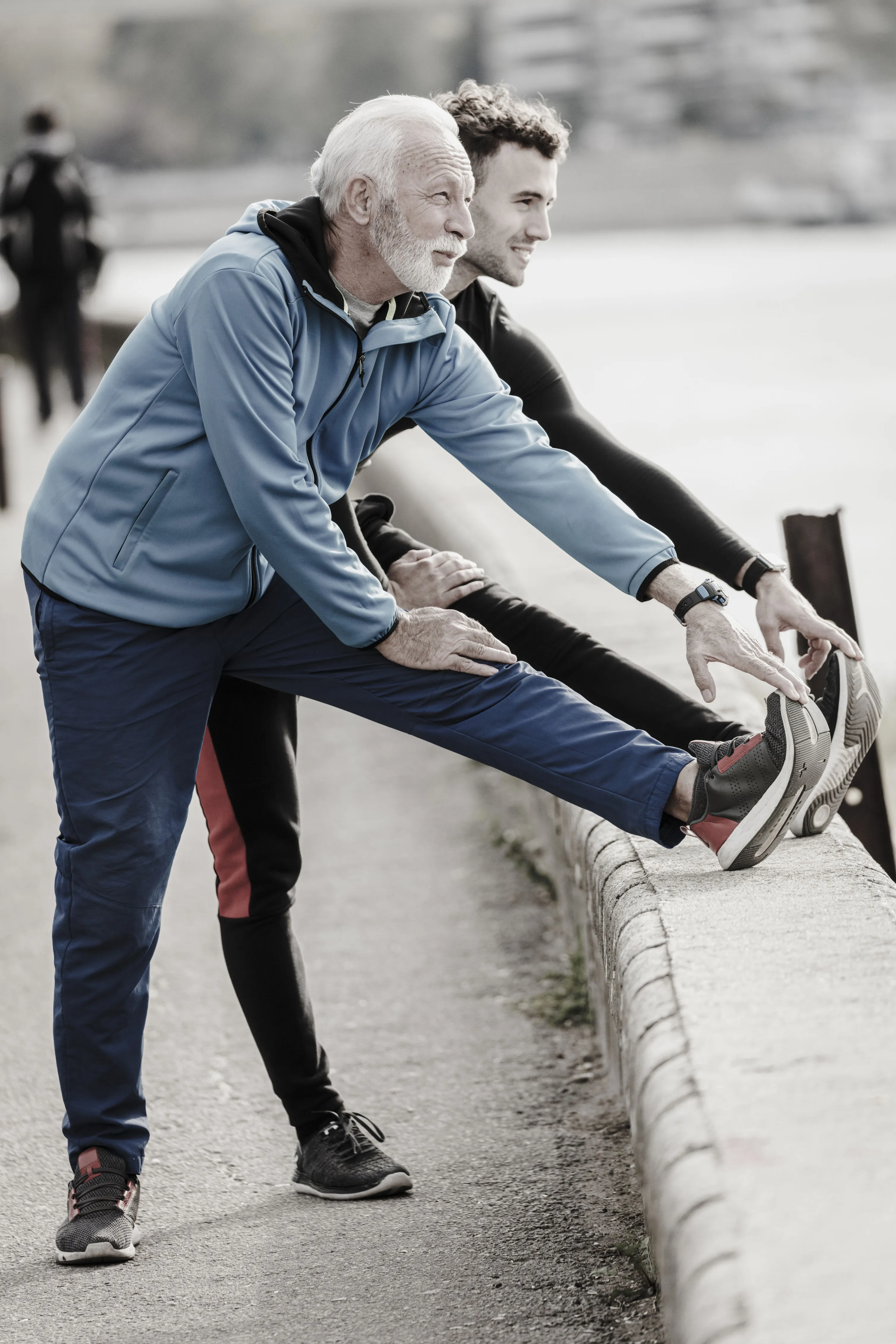 A young man and an old man are stretching their body
