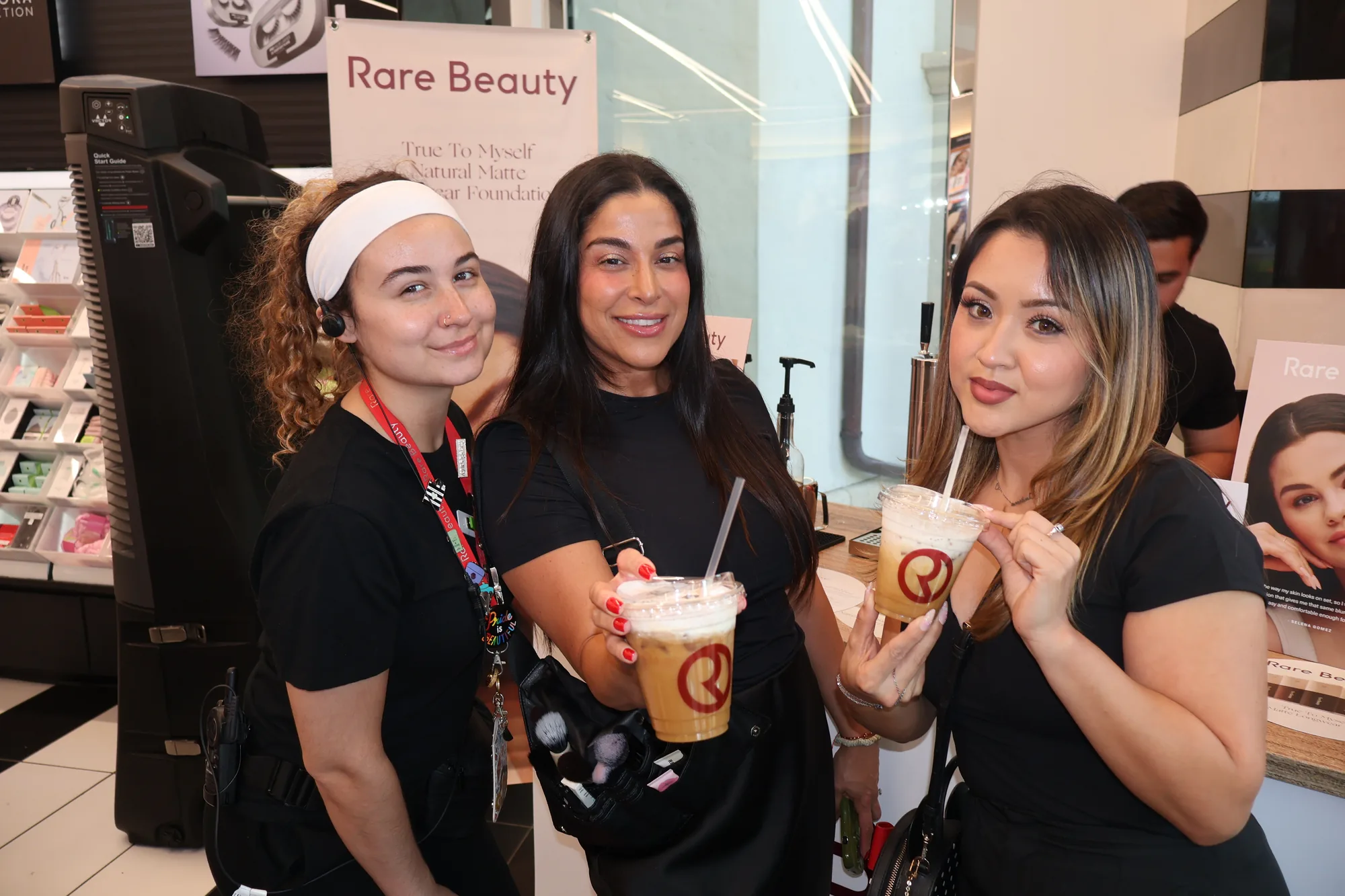 Guests holding branded Rare Beauty iced lattes at the Orlando coffee cart activation