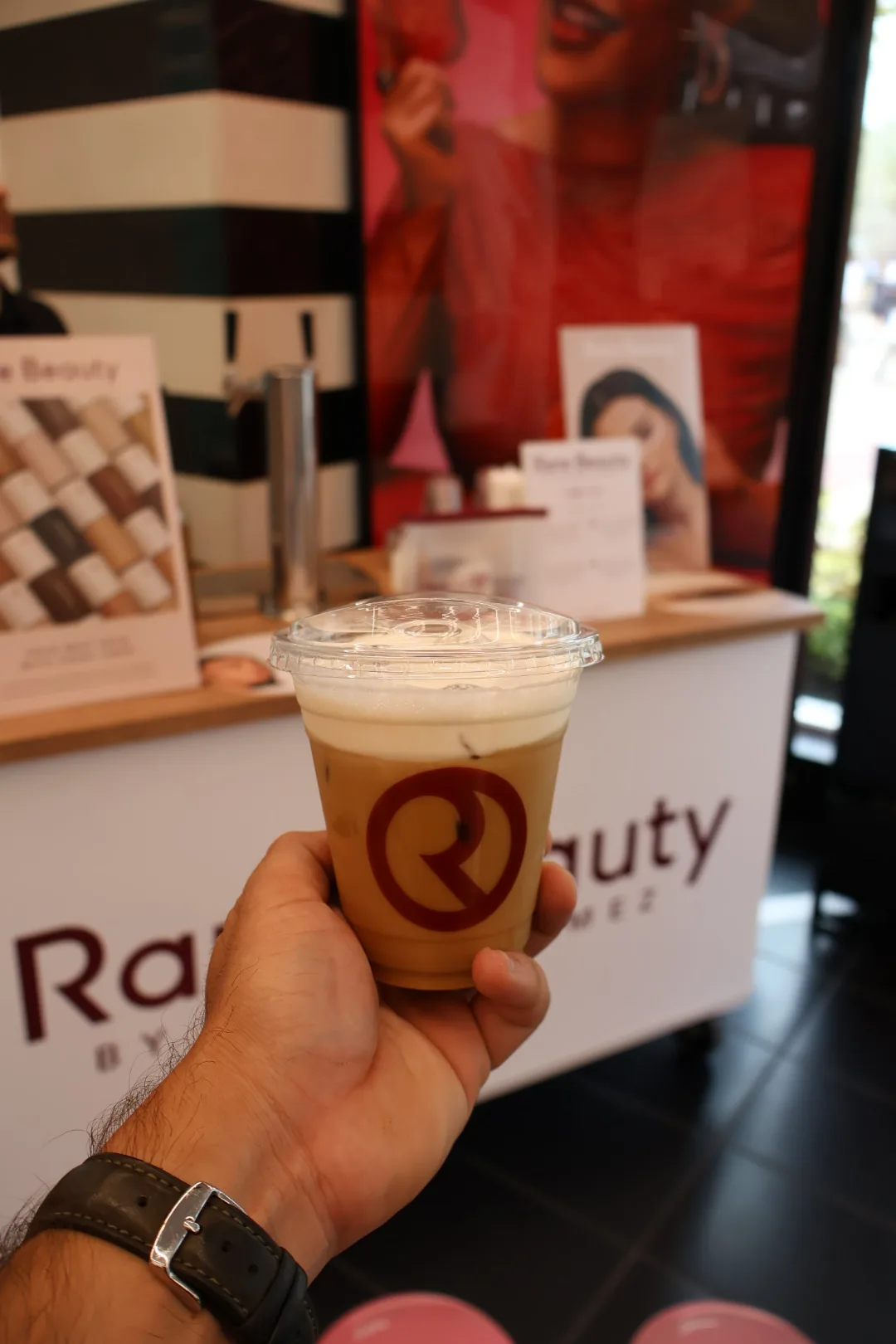 Close-up of an iced latte in a custom Rare Beauty branded cup at the Orlando activation