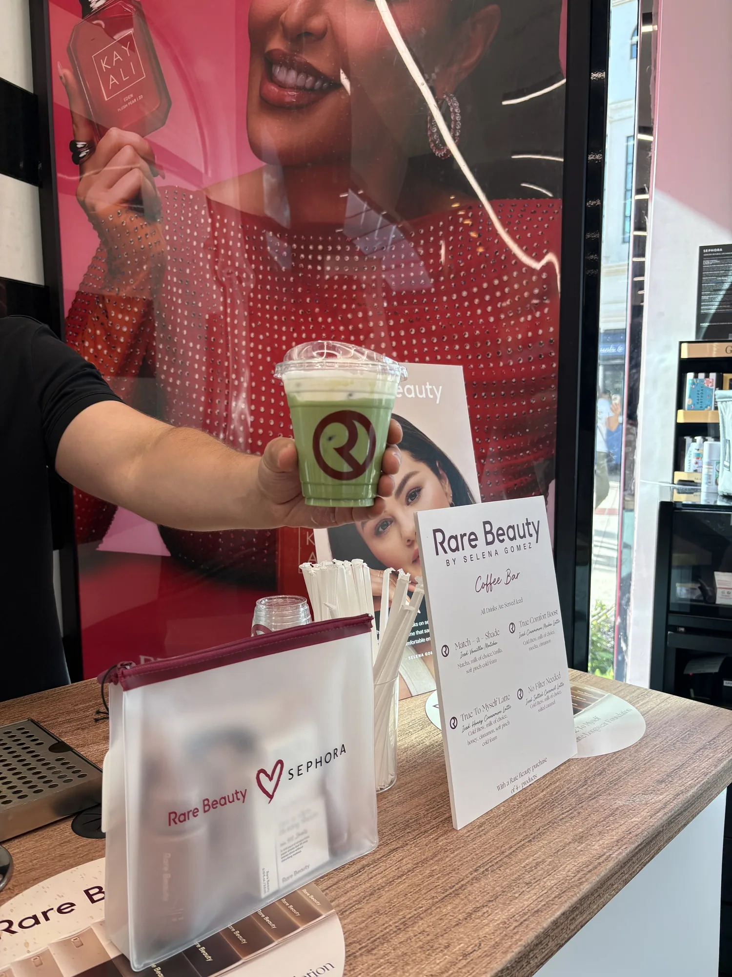 Iced matcha in a Rare Beauty branded cup beside a Sephora bag and custom coffee menu at Disney Springs
