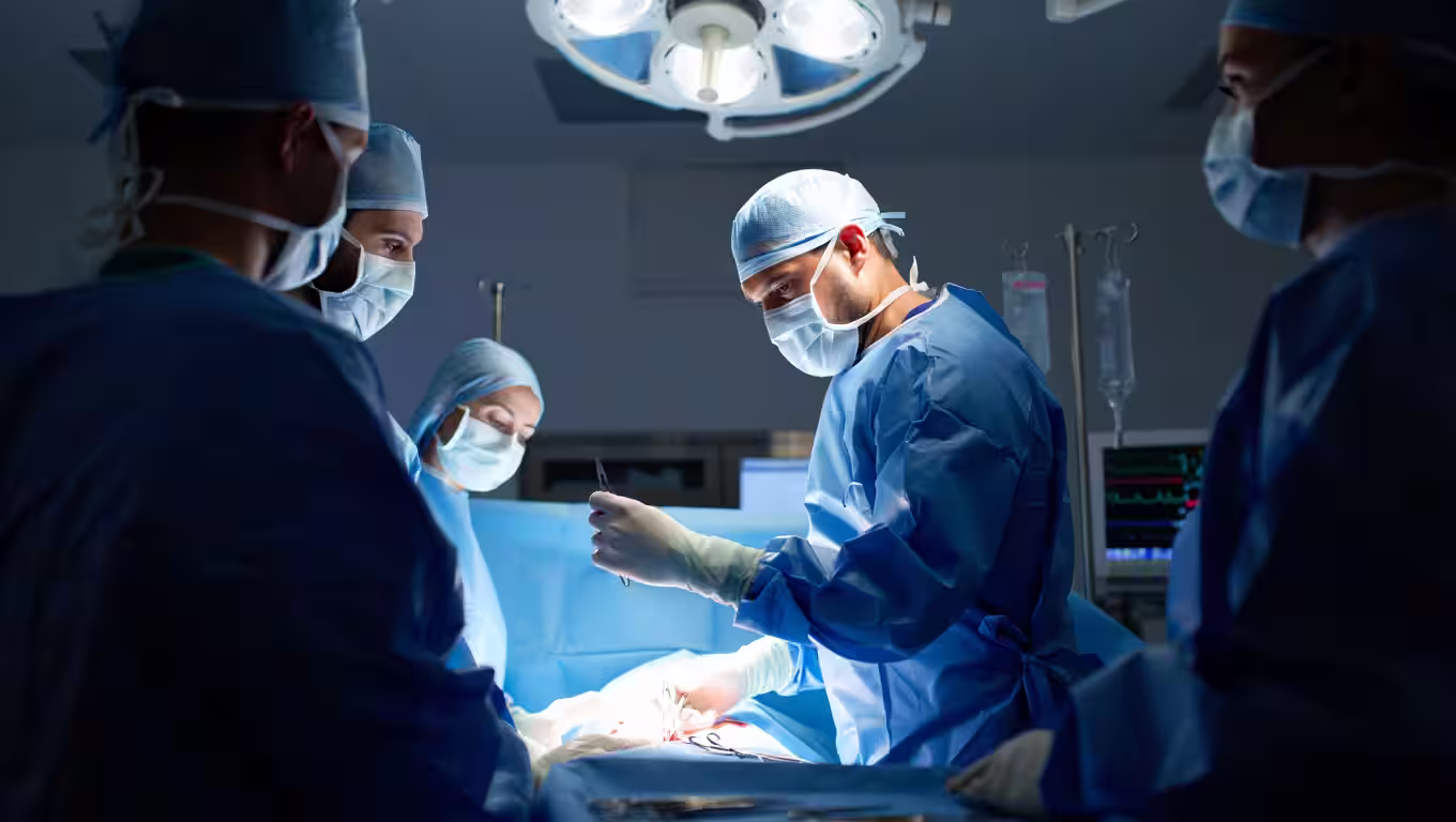 A cardiac surgeon in the operating room with a focused team