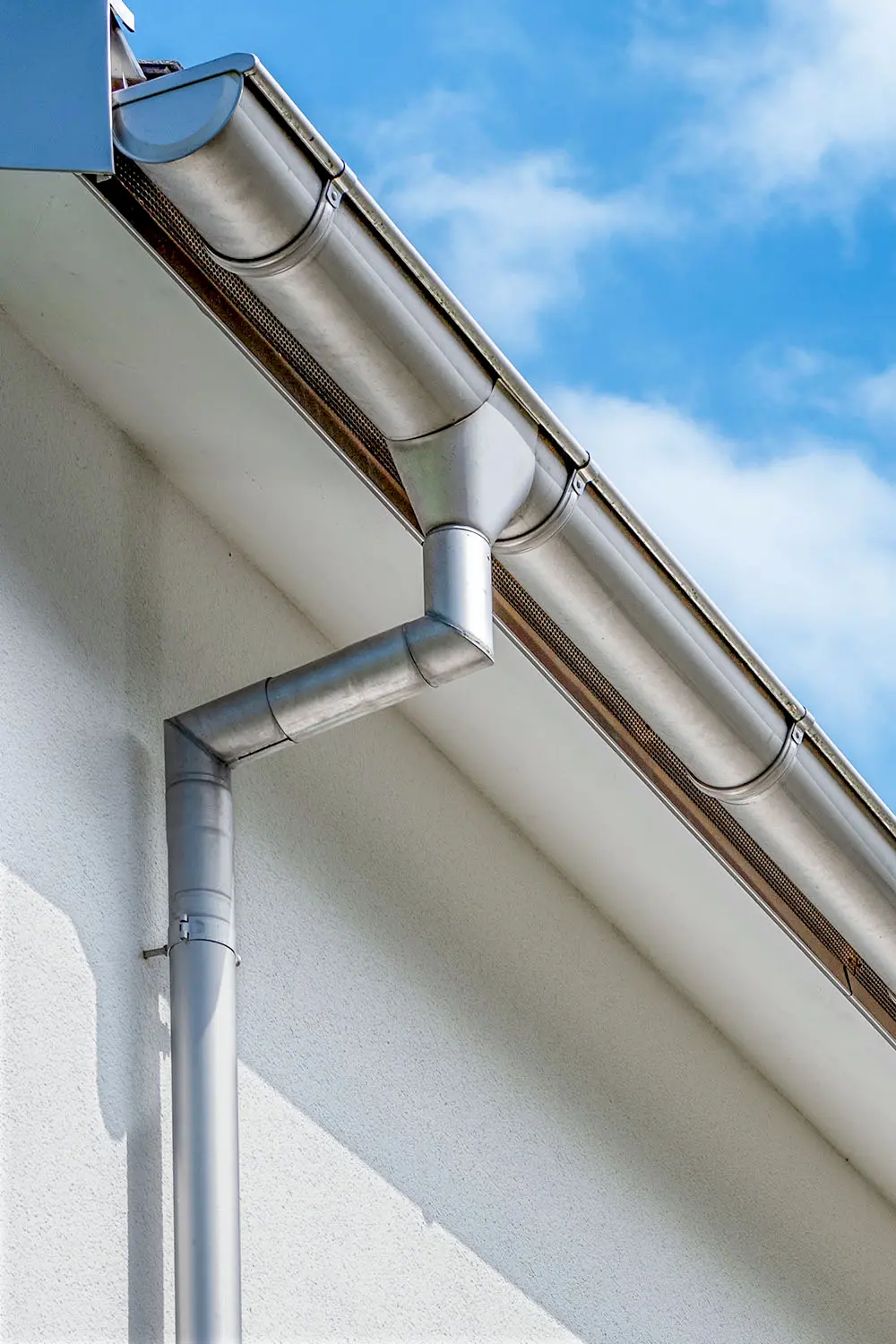 Spenglerarbeiten am Dach mit Zinkverkleidungen – Fallrohr, Dachrinne, Ortbrett und Stirnbrett aus Zink von Vögeli Holzbau