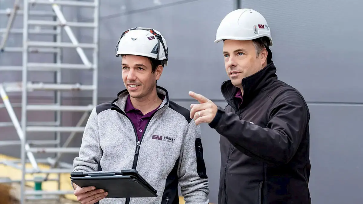 Zwei Mitarbeitende der Vögeli Holzbau AG besprechen eine Baustelle