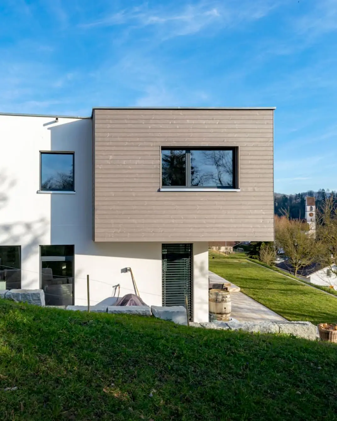 Aussenansicht Einfamilienhaus im Holzelementbau mit Holzfassade und grossen Fensterflächen