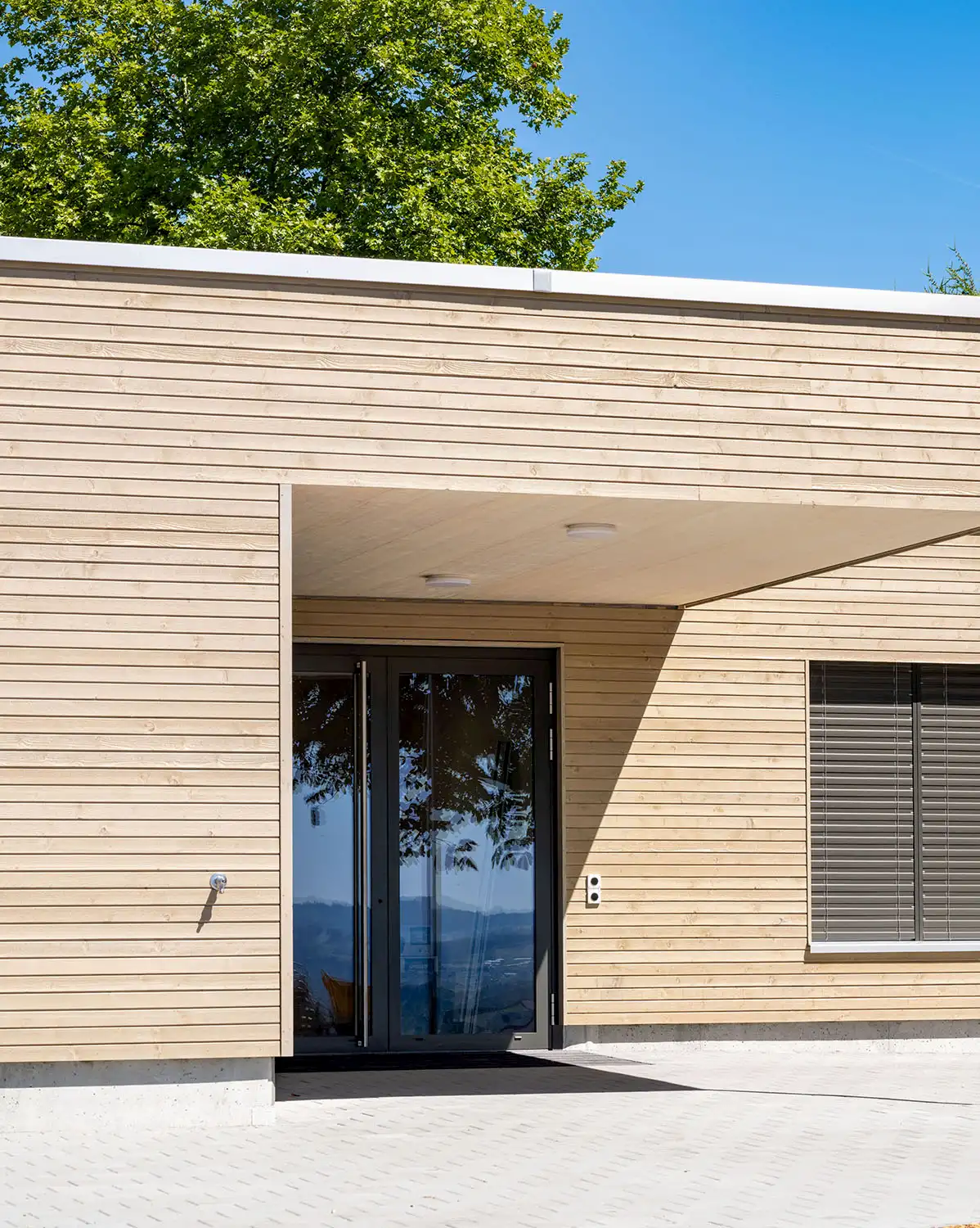 Moderne Holzfassade mit klarer Linienführung und Flachdach, energieeffizient gebaut von der Vögeli Holzbau AG in nachhaltiger Bauweise.