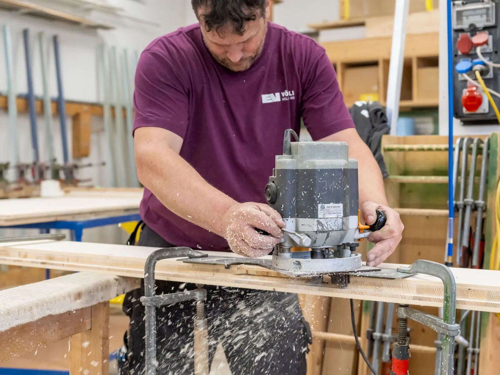 Detailaufnahme beim Fräsen eines Holzbauteils – Späne fliegen, präzises Handwerk und Qualität in der Holzverarbeitung.