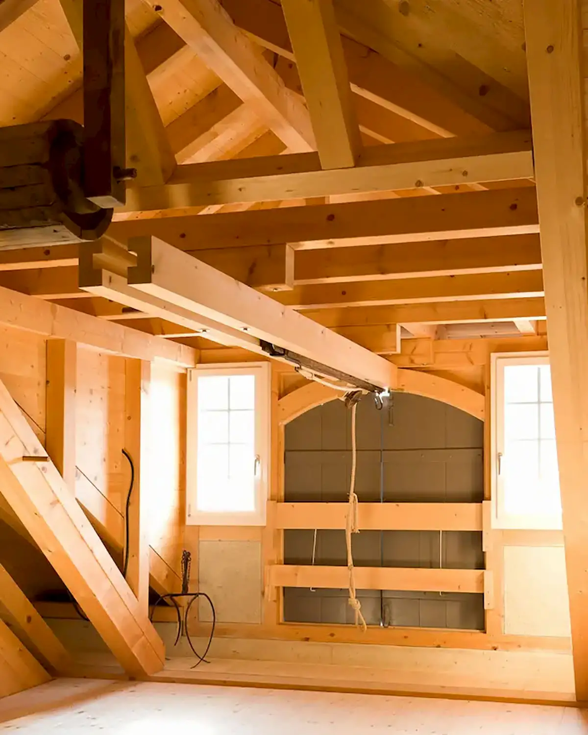 Historische Holzkonstruktion mit sichtbaren Trägern und Balken im Dachstuhl – traditionelles Zimmermannshandwerk und präzise Holzverbindungen.