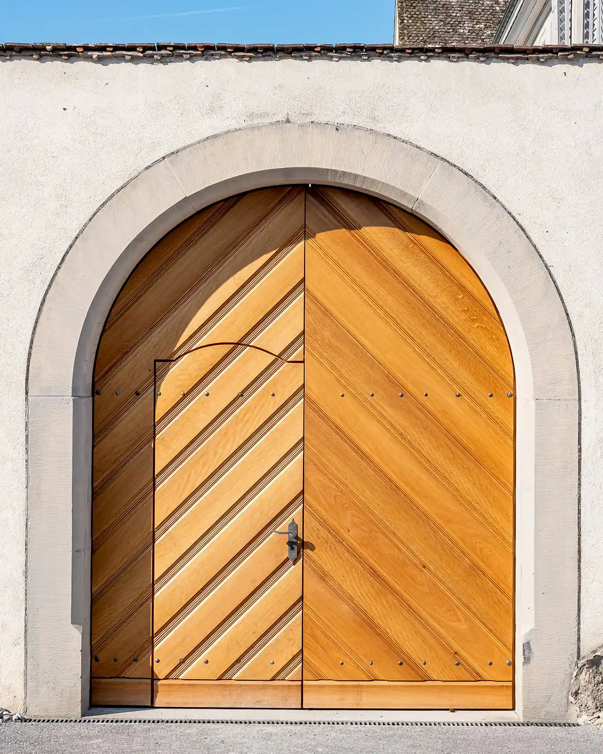 Handgefertigtes Holztor mit diagonalem Muster – Kombination aus traditioneller Zimmermannskunst und moderner Formgebung.