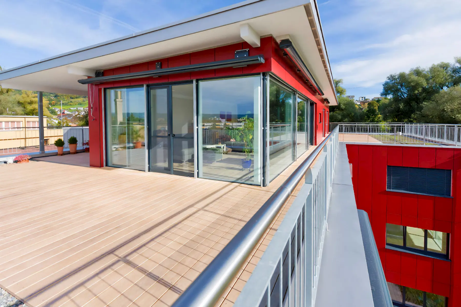 Dachterrasse mit edlem Holzbelag und Panoramasicht – langlebiger Terrassenrost von Vögeli Holzbau für moderne Wohnarchitektur.