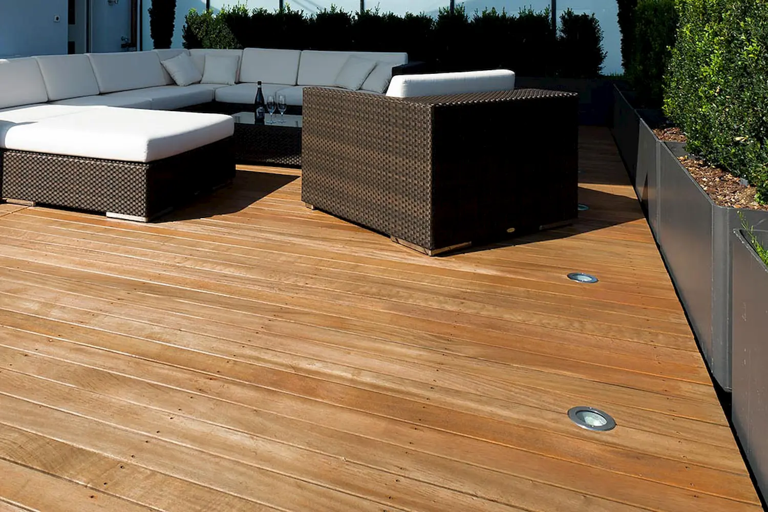 Moderne Dachterrasse mit edlem Sipo-Holzbelag, stilvoller Lounge und Sonnensegel – hochwertige Schreinerarbeit für entspannte Aussenräume.