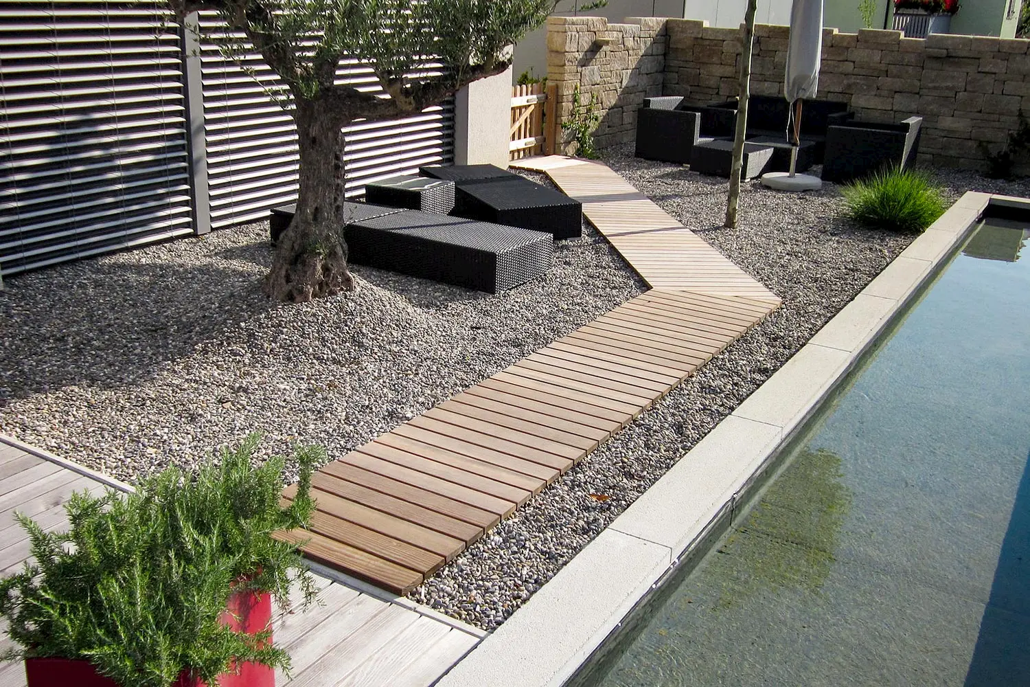 Abgeschlossenes Terrassenprojekt mit einem Schwimmteich und einem tollen Steingarten. Vögeli Holzbau hat diesen Terrassenboden erstellt