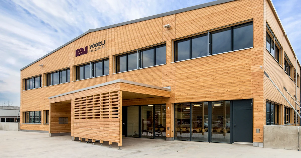 Moderner Neubau der Vögeli Holzbau AG mit Holzfassade und grossen Fenstern – nachhaltige Architektur und Handwerkskompetenz in Holzbauweise.