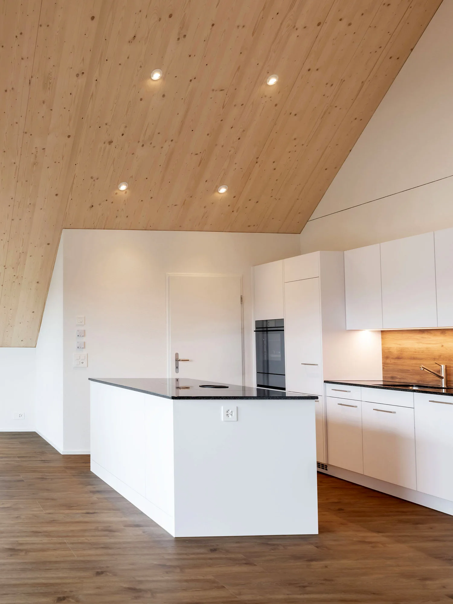 Helle, moderne Küche mit Holzdecke und Parkettboden – hochwertige Innenausstattung und präzise Schreinerarbeit von Vögeli Holzbau für Immobilienbau.