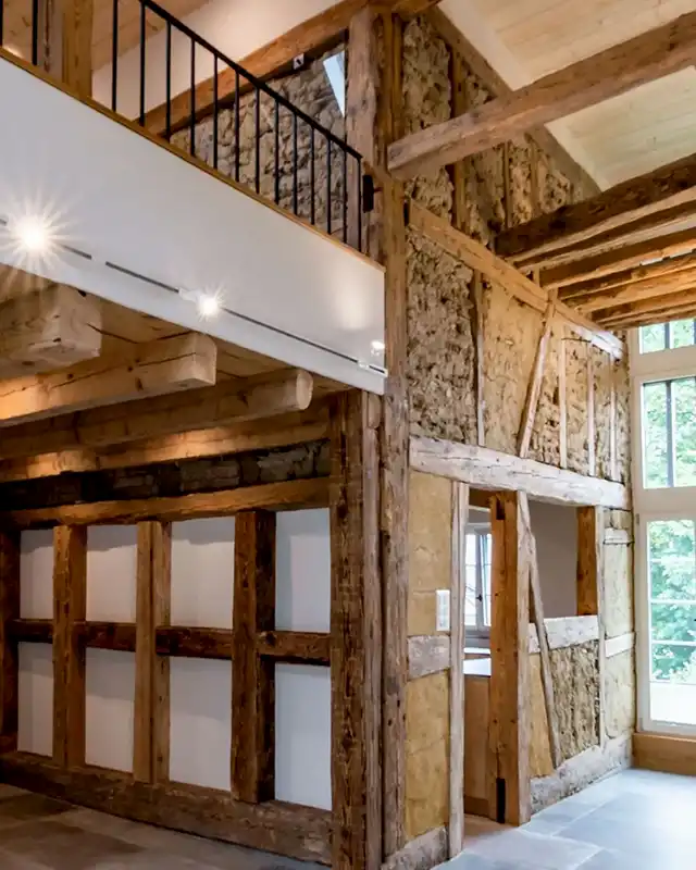 Modern saniertes Holztragwerk im historischen Holzbau mit nachhaltigen Lehm- und Strohfüllungen von Vögeli Holzbau