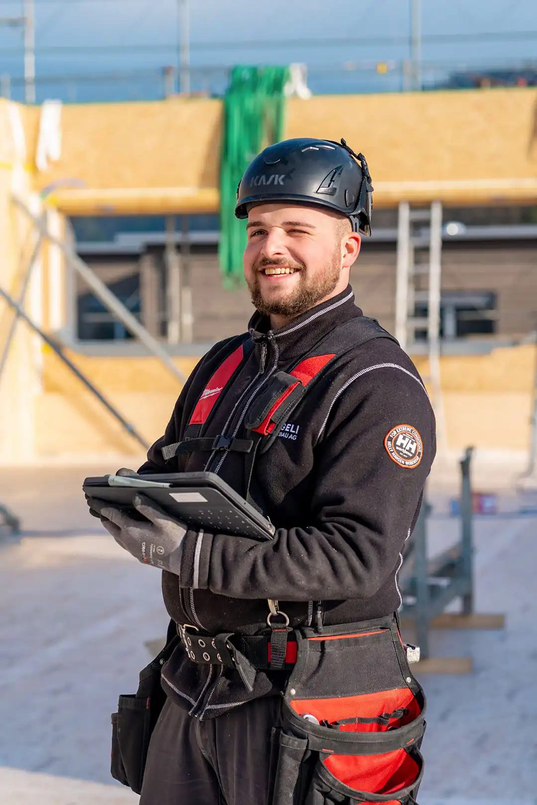 Mitarbeitender mit Tablet auf Baustelle