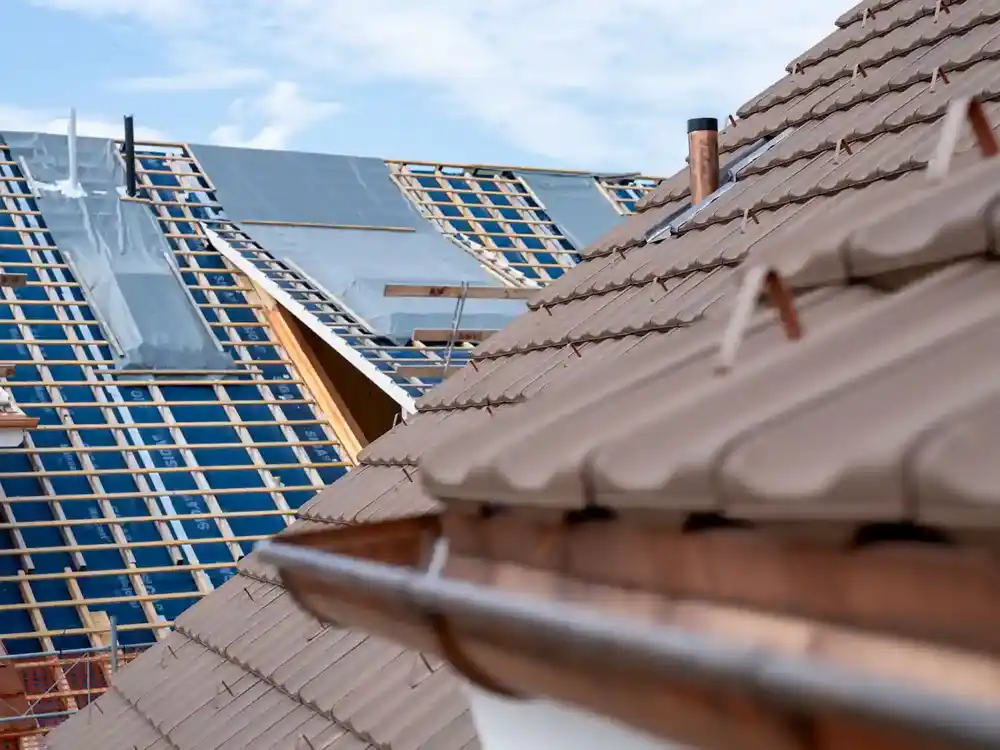 Dach mit Ziegeln und Dach bei dem demnächst Ziegel verlegt werden