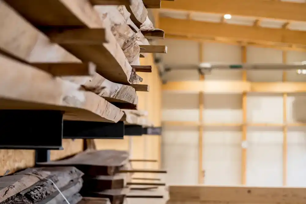 Holzbalken und Holzplatten in einem Lager mit Holzwänden und Dachträgern.