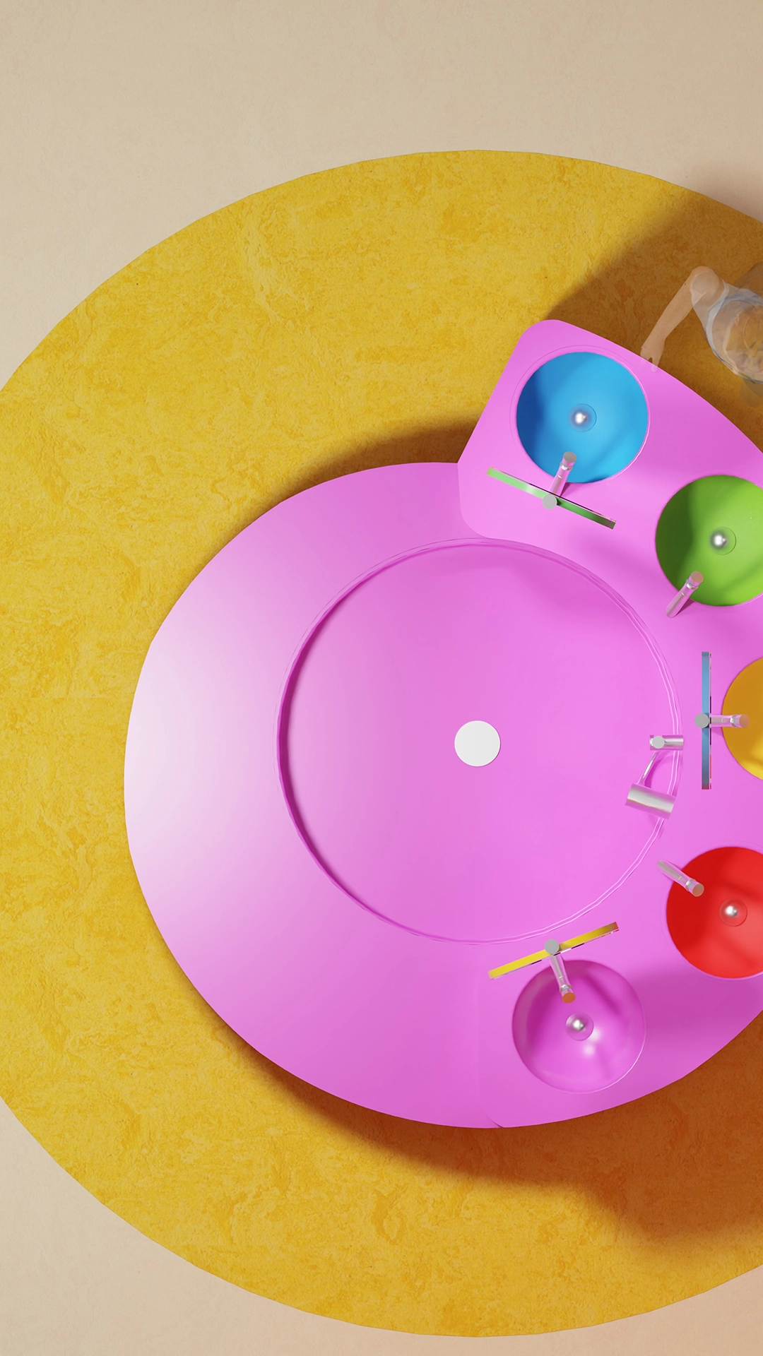 Top view of a colorful multi-sink washbasin with blue, green, yellow, red, and pink basins on a yellow circular rug.