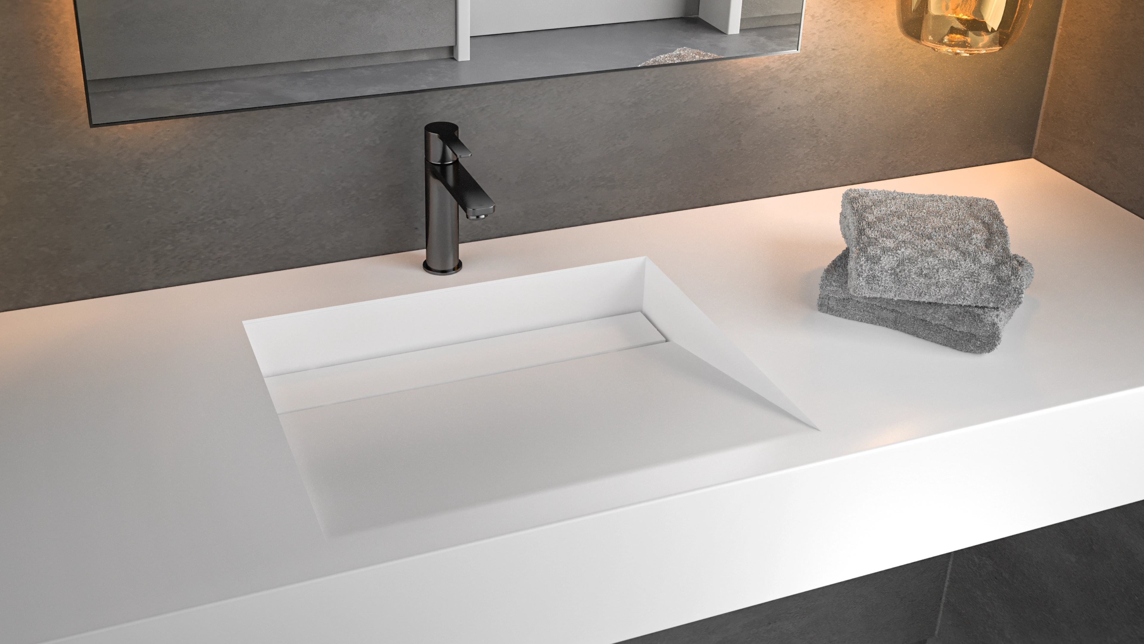 Modern white bathroom countertop with an integrated rectangular sink, black faucet, and folded gray towels on the right side.