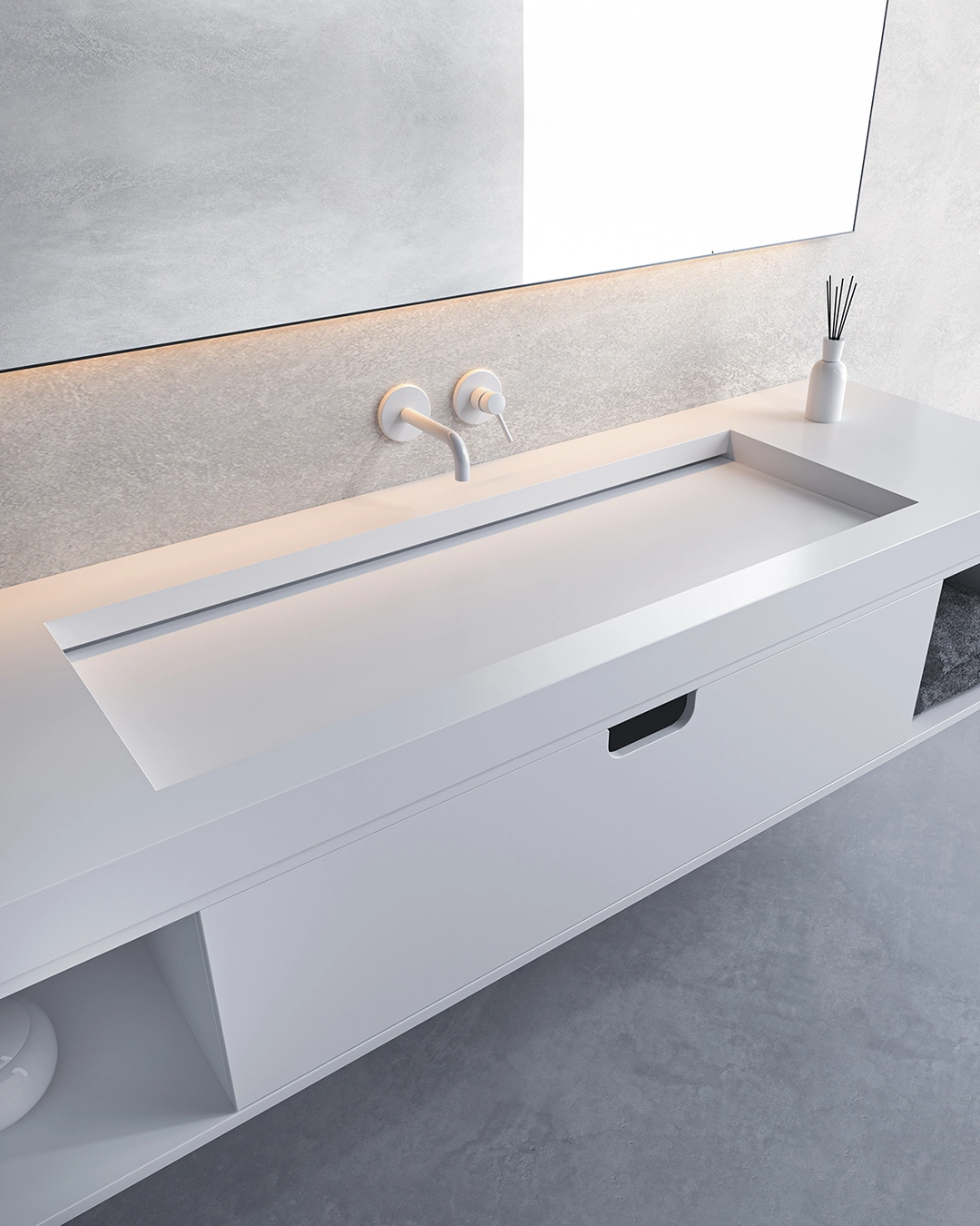 Minimalist white bathroom sink with integrated rectangular basin, wall-mounted faucet, and a small vase with reed diffusers on the countertop.