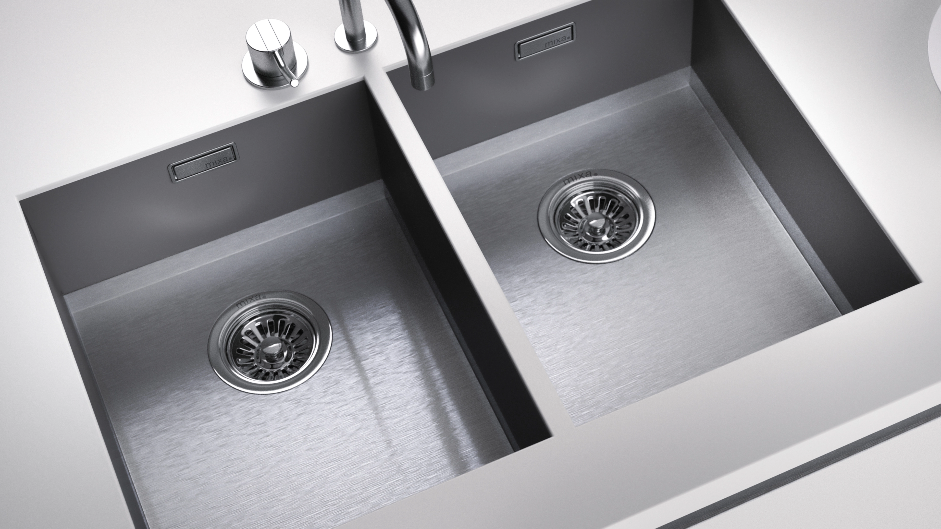 Stainless steel double kitchen sink with modern faucet and control knobs on white countertop.
