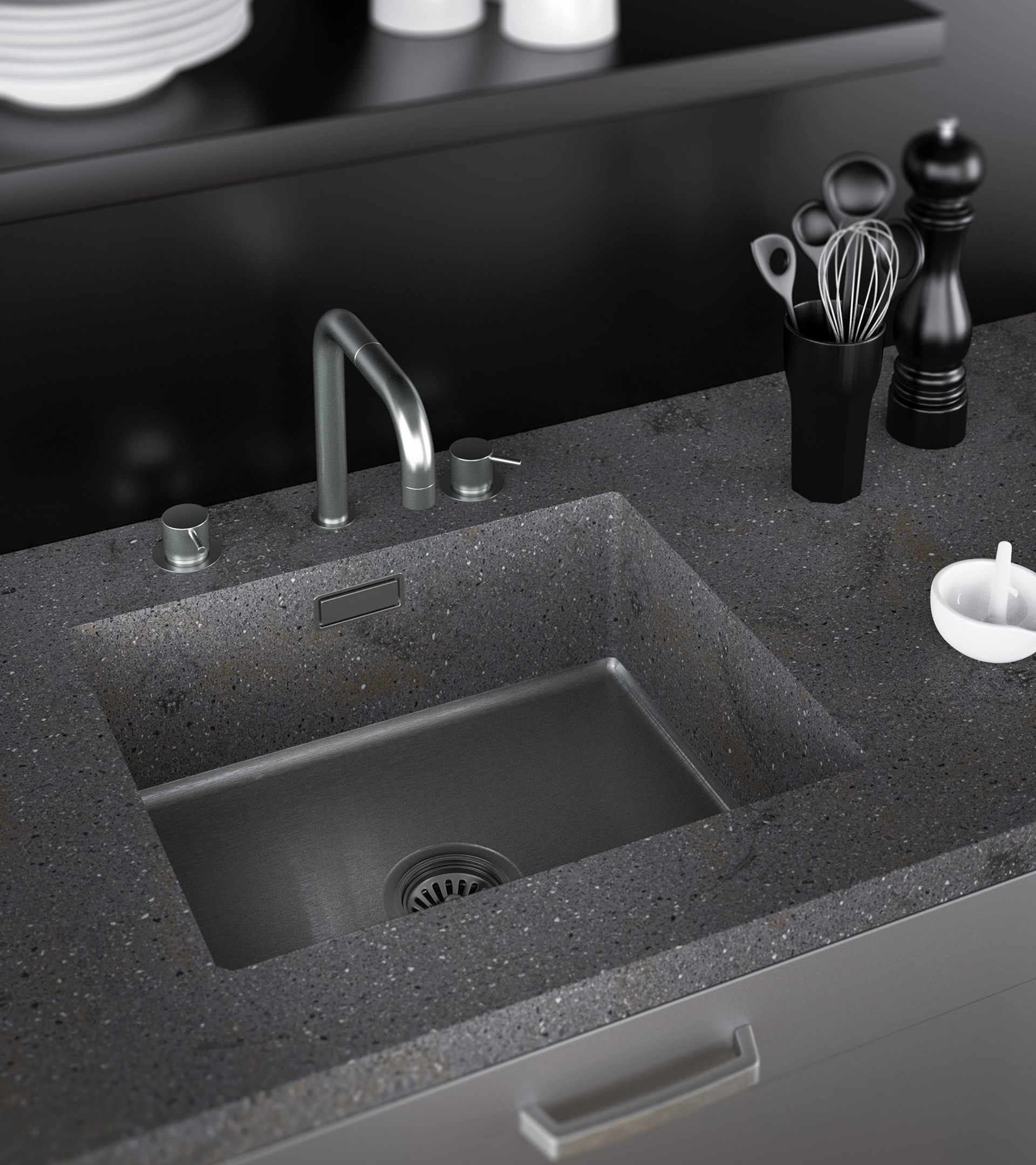 Modern kitchen sink with a stainless steel basin and faucet set into a dark speckled countertop, accompanied by a utensil holder with kitchen tools and a pepper grinder.