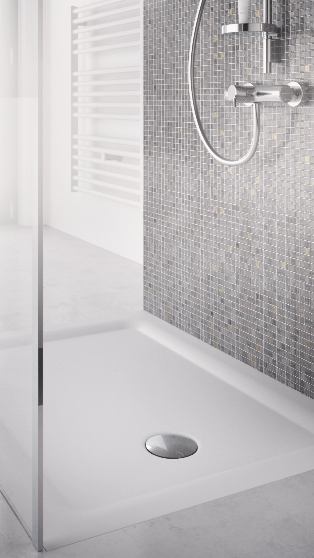 Minimalist shower area with a white rectangular base, mosaic gray wall tiles, and chrome shower fixtures.