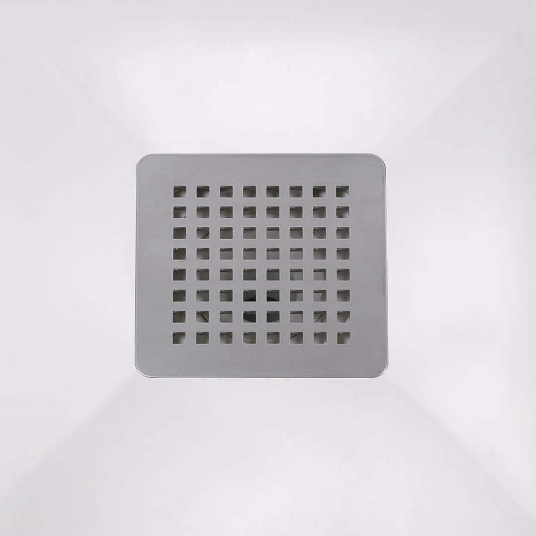 Top-down view of a square stainless steel shower drain grate with evenly spaced small square holes on a white shower floor.