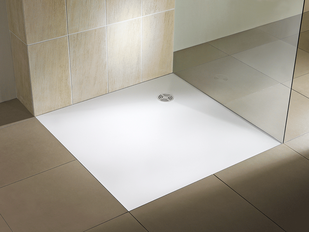 Modern walk-in shower area with beige wall tiles, a white shower base with a central circular drain, and a glass panel.