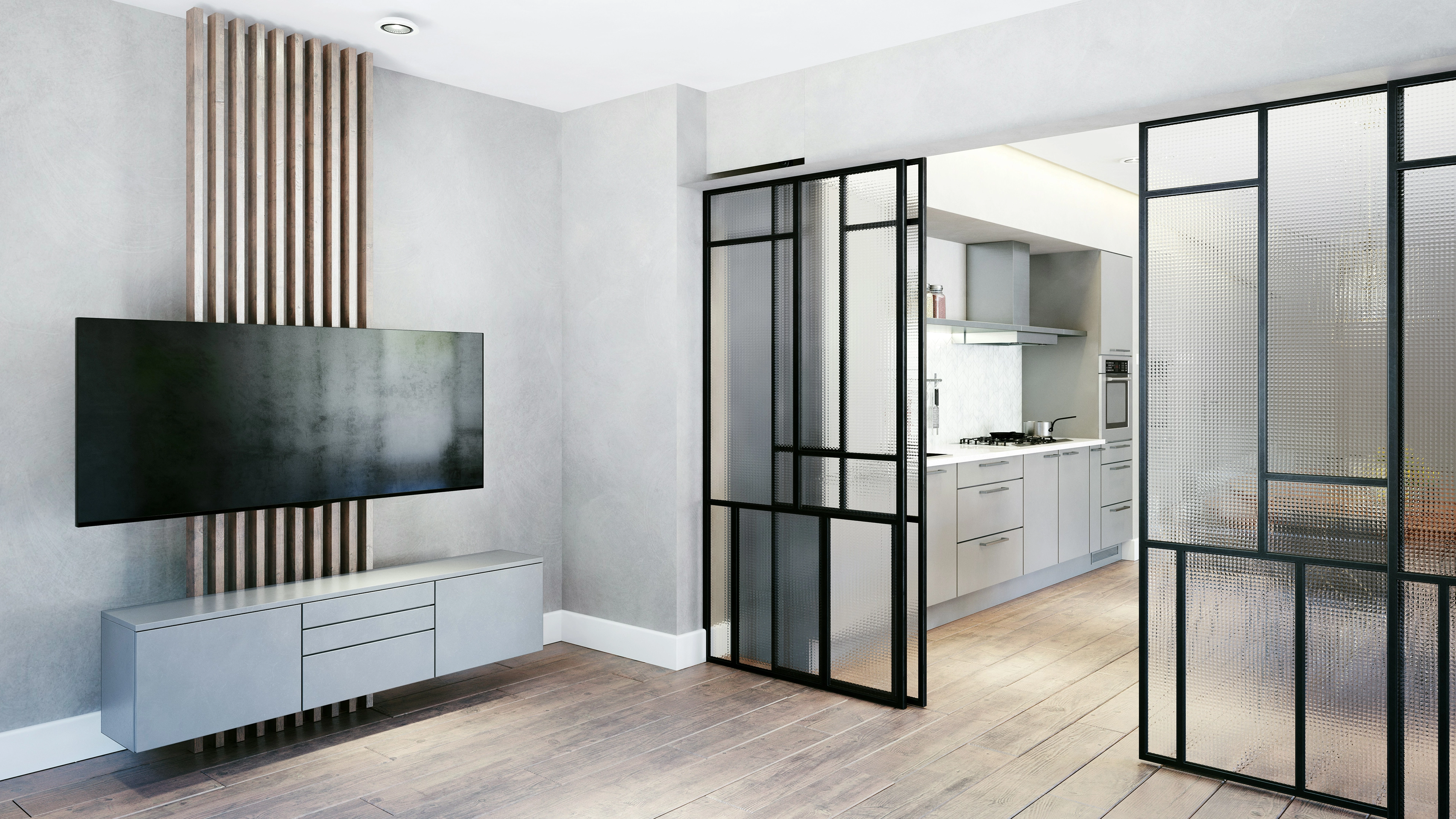 Modern living room with wall-mounted flat-screen TV above a sleek gray cabinet, wooden flooring, and a partially visible kitchen separated by black-framed frosted glass sliding doors.