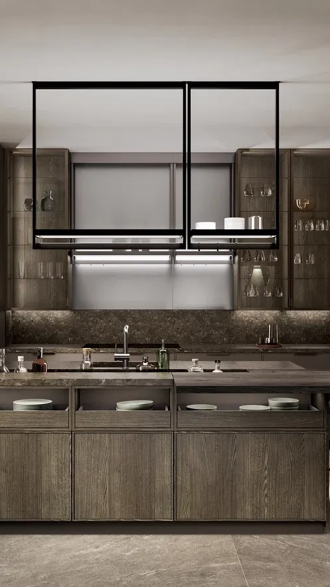 Modern kitchen with dark wood cabinetry, marble countertops, a central island with sink and stove, and overhead rectangular pendant lights.