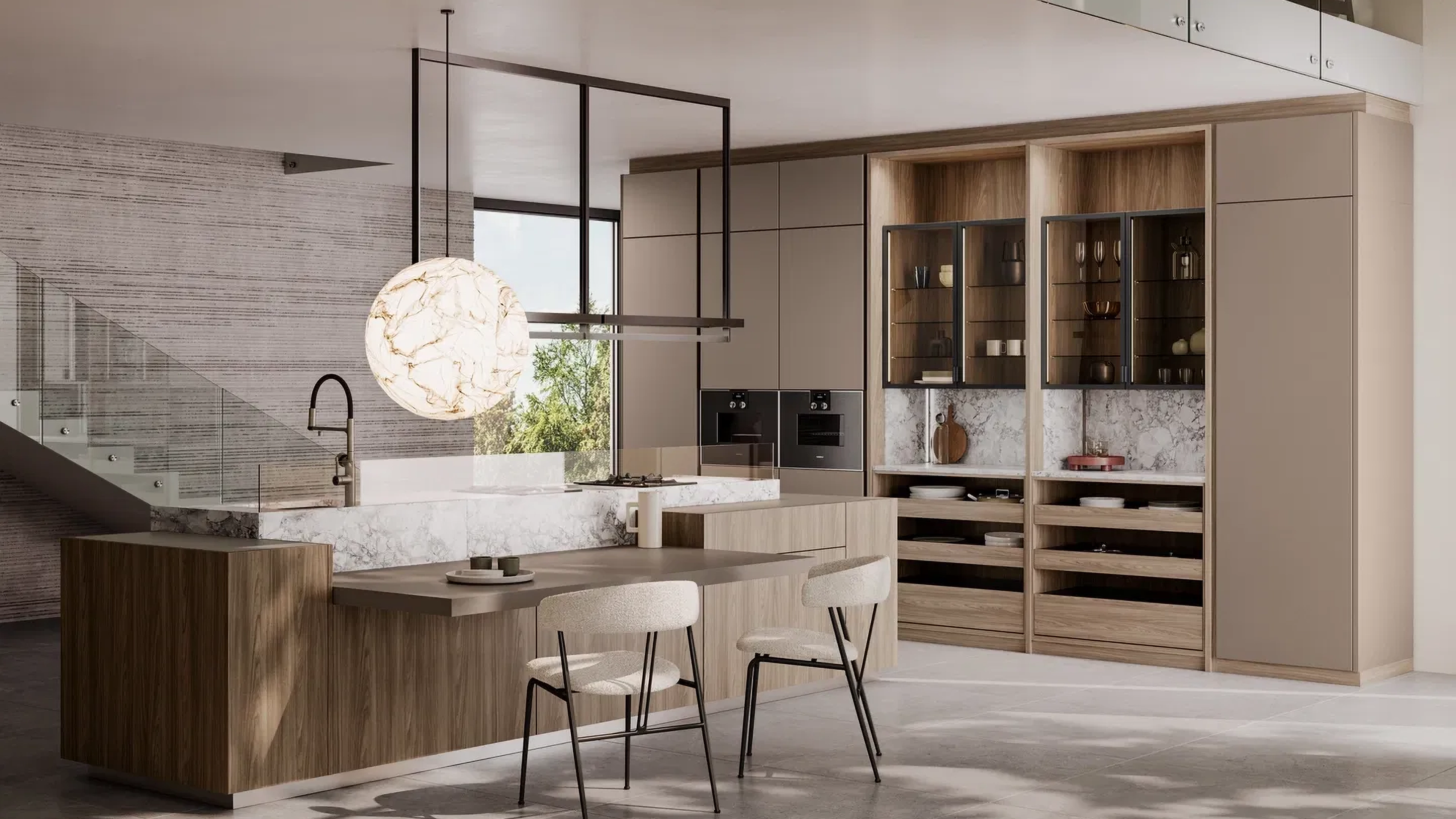Modern kitchen with wood cabinetry, marble countertops, two beige chairs at an island, and a large spherical pendant light.