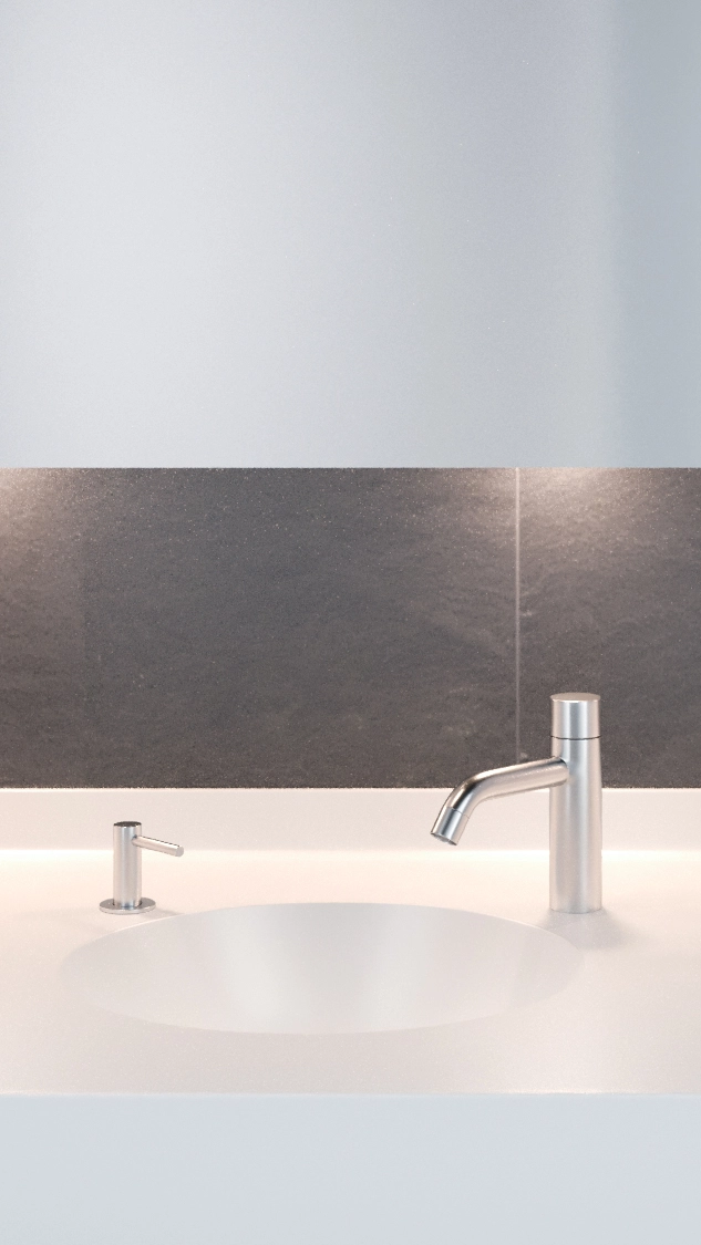 Modern white sink with a minimalist silver faucet and soap dispenser against a dark tiled wall.