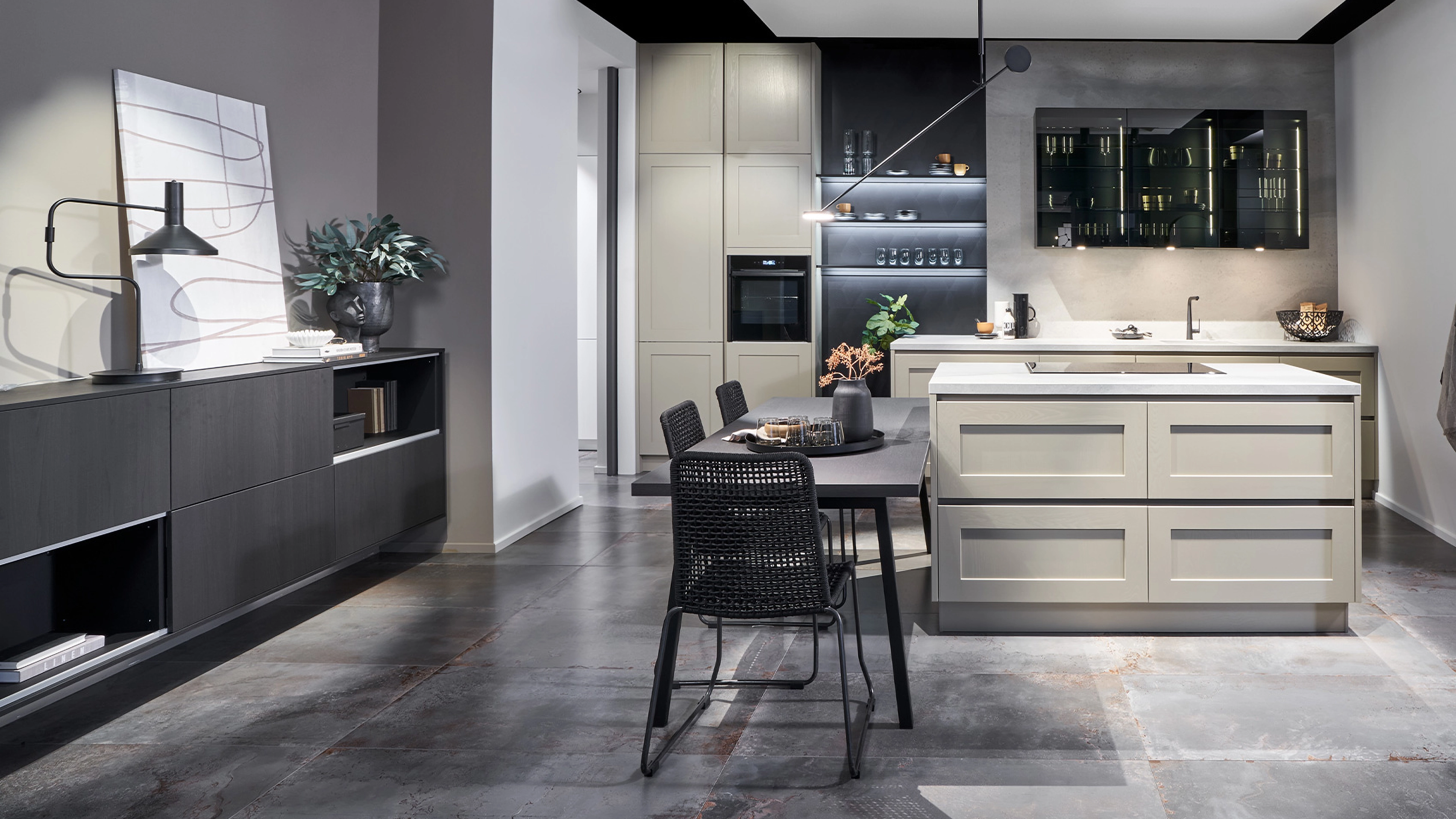 Moderne Küche mit grauem Boden, beiger Kücheninsel, schwarzem Esstisch und schwarzen Stühlen in einem minimalistischen Raum.