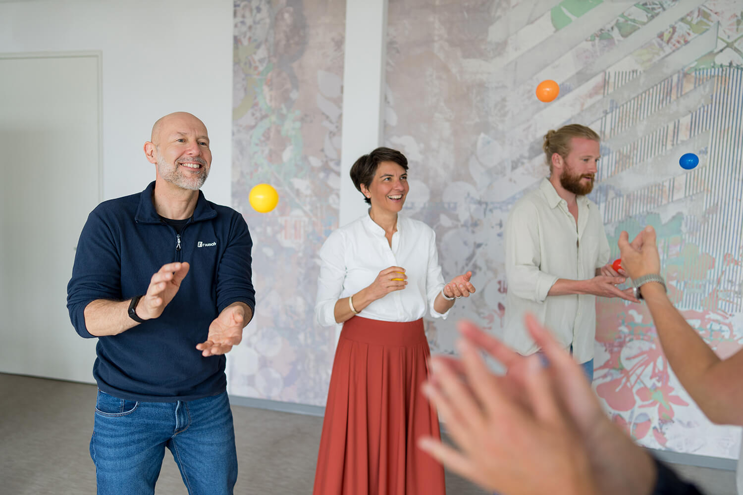 Beratungsgespräch im Seminarraum – eine Person erklärt mit ausgebreiteten Armen, Gegenüber hört zu