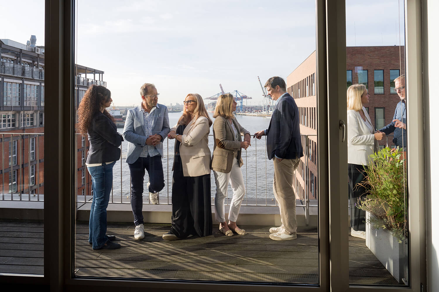 Drei Teilnehmende stehen auf farbigem Persönlichkeitsrad (Lumina) im Seminarraum